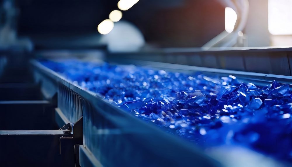 搬送ラインを流れる青い再生プラスチックフレーク
